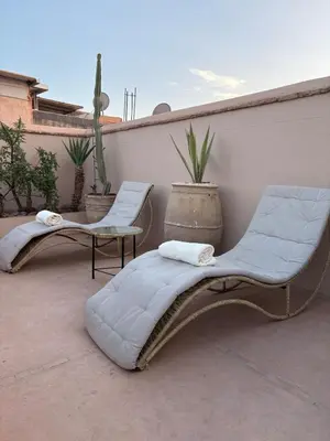 two chairs and a couch sitting on a patio at Riad Elena l Private Riad with heated Pool in Marrakech l 3 rooms in Marrakech