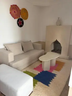 a living room with a couch and a fireplace at Riad Elena l Private Riad with heated Pool in Marrakech l 3 rooms in Marrakech