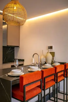 a kitchen with a dining table with orange chairs at Luxury apartment near to McDonald's in Marrakech