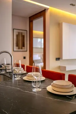 a table with plates and wine glasses on it at Luxury apartment near to McDonald's in Marrakech