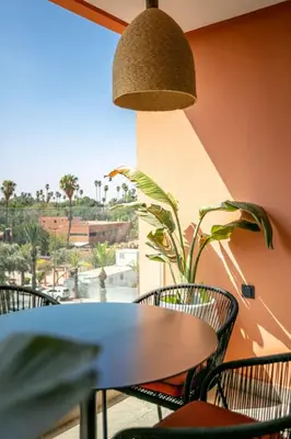 a table and chairs on a balcony with a view at Luxury apartment near to McDonald's in Marrakech