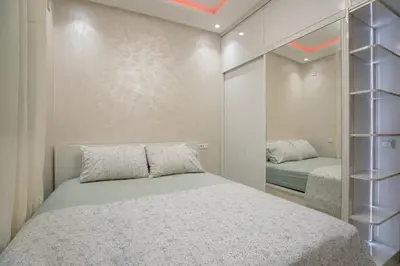 a bedroom with a bed and a mirror at Titrit Apartment Marrakech in Marrakech