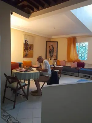 a man sitting at a table in a living room at Marrakech en toute simplicité in Marrakech