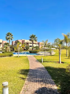a brick path in a park with palm trees at Prestigia jade in Marrakech