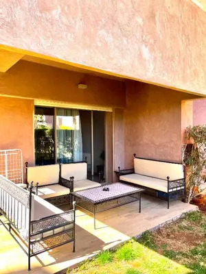 three benches sitting on a patio with a building at Prestigia jade in Marrakech