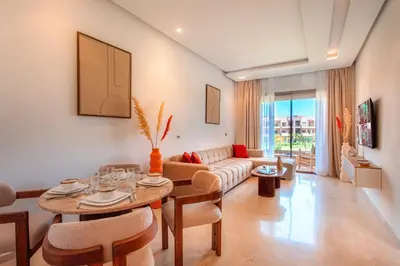a living room with a couch and a table at Appartement de charme vue piscine et espace vert in Marrakech