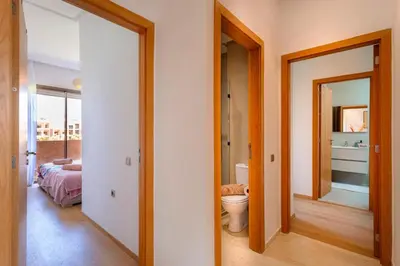 a bathroom with a toilet and a bedroom at Appartement de charme vue piscine et espace vert in Marrakech