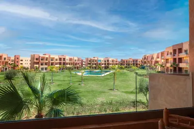 a view from a window of a courtyard with a pool at Appartement de charme vue piscine et espace vert in Marrakech