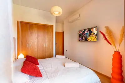 a bedroom with a white bed with red pillows at Appartement de charme vue piscine et espace vert in Marrakech