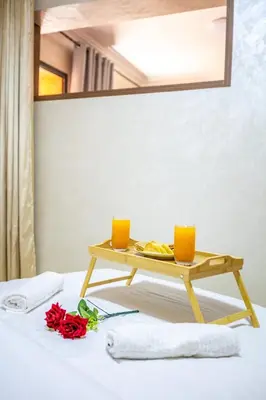 a table with two orange candles on top of a bed at Stylish Apartment in Gueliz by Train & Majorelle in Marrakech