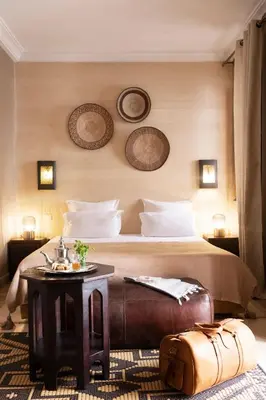 a hotel room with a bed and a table with a suitcase at Riad RK Suites & Spa in Marrakech