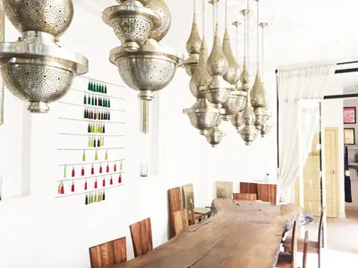 a dining room with a long table and chandeliers at Riad 144 in Marrakech