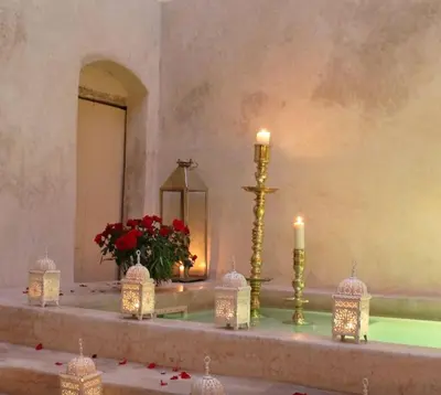 a altar with candles and a vase with red flowers at Riad 144 in Marrakech