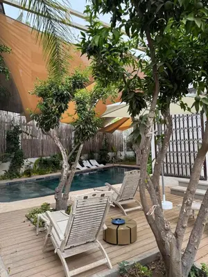 two lounge chairs and a swimming pool with trees at Villa en centre Ville de Marrakech, 5 Chambres, Piscine, Rooftop in Marrakech