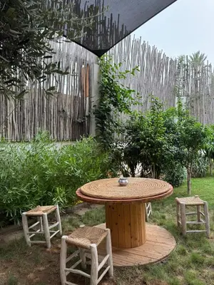 a picnic table and two stools in a yard at Villa en centre Ville de Marrakech, 5 Chambres, Piscine, Rooftop in Marrakech
