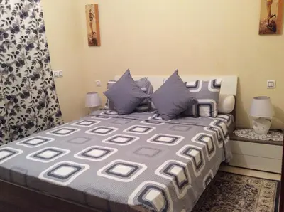 a bedroom with a bed with blue and gray pillows at Apartment Majdoline in Marrakech