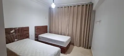 a small room with two beds and a window at Apartment Majdoline in Marrakech