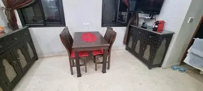 a dining room table with two chairs and a television at Apartment Majdoline in Marrakech