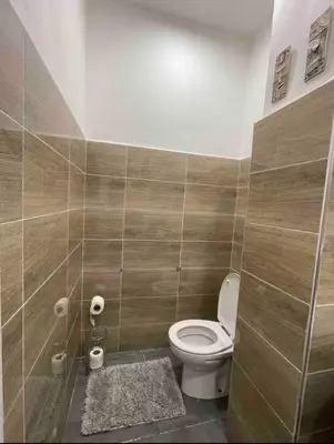 a bathroom with a toilet and a tiled wall at Blue Majorelle in Marrakech