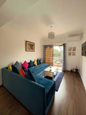 a living room with a blue couch with colorful pillows at Blue Majorelle in Marrakech