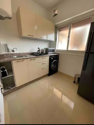 a small kitchen with a washer and dryer in it at Blue Majorelle in Marrakech