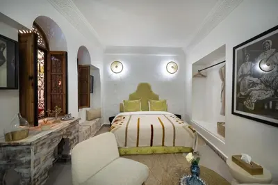 a bedroom with a bed and a chair in it at Riad Dar Lghizlane in Marrakech