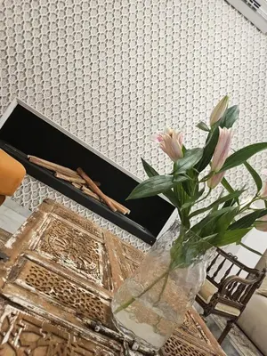 a vase with pink flowers on a table with a laptop at Riad Dar Lghizlane in Marrakech
