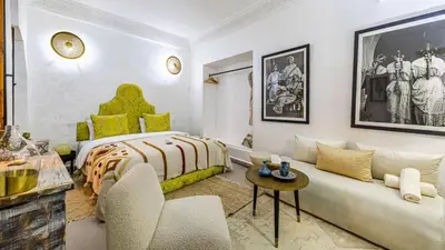 a bedroom with a king sized bed and a couch at Riad Dar Lghizlane in Marrakech