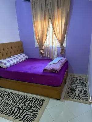 a bedroom with a bed with purple sheets and a window at Apparemment à Marrakech in Marrakech