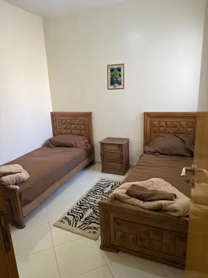 a bedroom with two beds and a rug at Apparemment à Marrakech in Marrakech