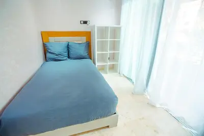 a bedroom with a bed with blue sheets and a window at Appartement XXL résidence privée piscine Dar Dmana PALMERAIE in Marrakech