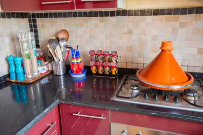 a kitchen counter with an orange pot on a stove at Appartement XXL résidence privée piscine Dar Dmana PALMERAIE in Marrakech