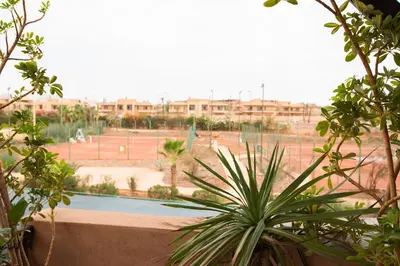 a view of a tennis court from a building at Appartement XXL résidence privée piscine Dar Dmana PALMERAIE in Marrakech