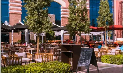 an outdoor restaurant with tables and chairs and a sign at Suite Ultra Deluxe, Babylone, Ultra Confort, Hyper-Centre, Marrakesh in Marrakech