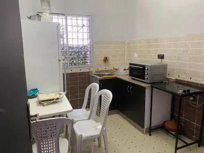 a kitchen with chairs and a counter with a microwave at AJ Apartment Ideal for Families, Married Couples, and Solo Travelers in Marrakech