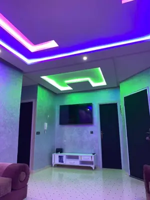 a living room with green and purple lights on the ceiling at AJ Apartment Ideal for Families, Married Couples, and Solo Travelers in Marrakech