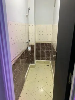 a bathroom with a shower and a tiled floor at AJ Apartment Ideal for Families, Married Couples, and Solo Travelers in Marrakech