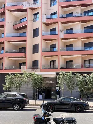 two cars parked in front of a building at Hivernage 50 in Marrakech