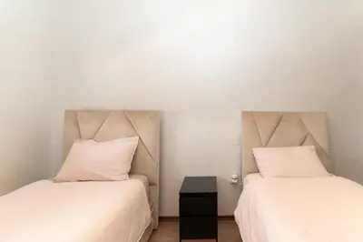 two beds sitting next to each other in a room at Beautiful accommodation with 2 pools & fast WiFi in Marrakech