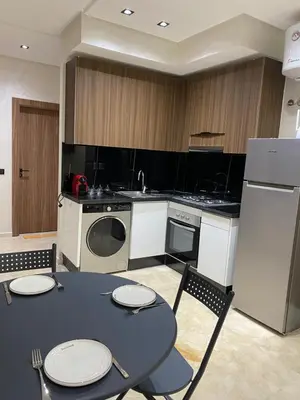 a kitchen with a table and chairs and a kitchen with a refrigerator at Studio Jasmine in Marrakech