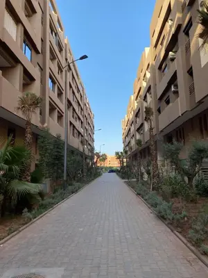 an empty street between two large apartment buildings at Studio Jasmine in Marrakech