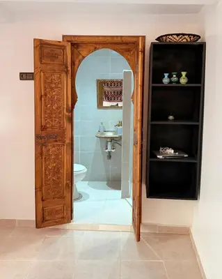 a bathroom with a shower with a toilet and a mirror at Dar Skouri in Marrakech