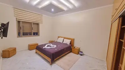 a bedroom with a bed with purple sheets and a window at Villa Zohra in Marrakech