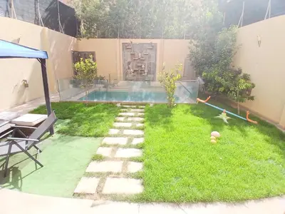 a small backyard with a swimming pool and grass at Villa Zohra in Marrakech