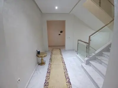 a hallway with stairs and a table and a stair case at Villa Zohra in Marrakech