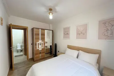 a bedroom with a white bed and a bathroom at NS 53 by KMREI Properties in Marrakech
