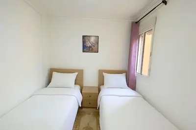 two beds in a room with white walls at NS 53 by KMREI Properties in Marrakech