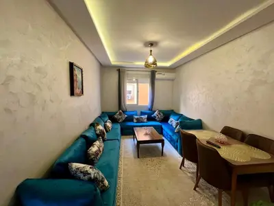 a living room with a blue couch and a table at NS 53 by KMREI Properties in Marrakech