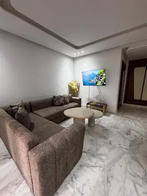 a living room with a couch and a table at Garden level & pool, cozy apartment queen size bed in Marrakech