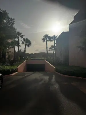 an empty parking lot with palm trees and a building at Garden level & pool, cozy apartment queen size bed in Marrakech